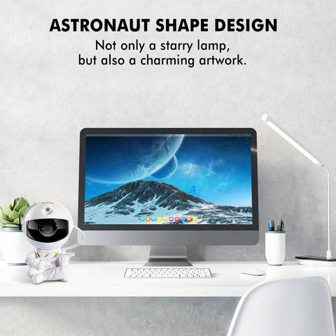 Desktop setup with astronaut-shaped Star Galaxy Projector Night Light For Kids And Adults Nebula Ceiling Decor next to monitor