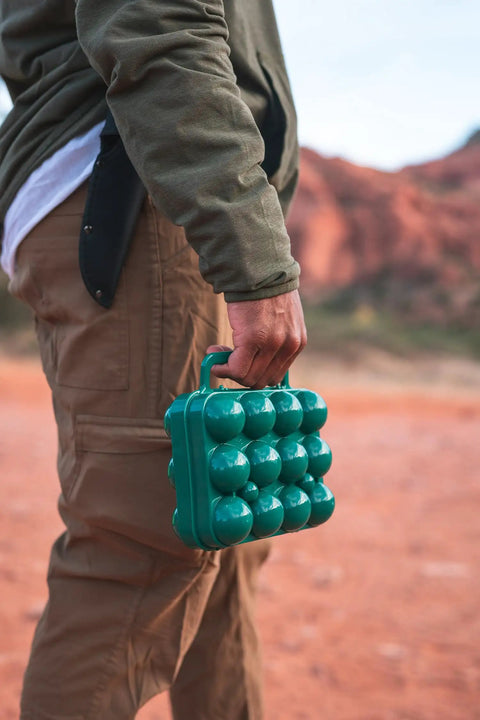 Person carrying Tough 12-Egg Plastic Carrier With Locking Lid, Molded Handle, And Secure Fit For Camping in outdoor setting