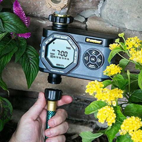 Hydrologic 4 Zone Digital Water Timer With Smart Zone Control attached to hose among garden flowers