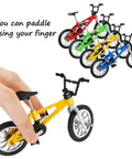 Hand holding yellow bike from 12 Pack Mini Finger BMX Bikes For Kids And Adults, Reconfigurable Tiny Bicycle Toys, Vintage Color Mix.