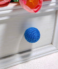Close-up of a blue jute rope knob on a white cabinet, part of 6 Pack Jute Rope Cabinet Knobs Set 1.26 Inch Round Wood Knobs For Kitchen Cabinets