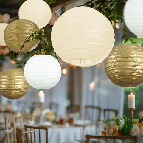 18 Piece Metallic Gold Paper Lantern Set For Weddings And Parties Assorted 8 10 And 12 Inch Sizes Reusable Easy Assemble Hanging Japanese Lanterns In Gold Cream Ivory White Party Ready Decor For Christmas Birthdays Baby Showers hanging at a decorated table setting