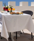 Outdoor table with white tablecloth secured by Six Pack Black Tablecloth Weights With Resin Round Ball Hangers And Metal Clips Heavy Duty Cloth Clips For Outdoor Parties Picnics And Family Dinners Keeps Table Covers In Place Against Wind.