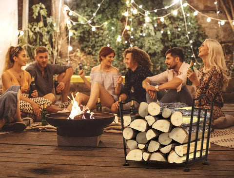 Foldable Firewood Rack For Indoor And Outdoor Use, Rust-Resistant, holding logs at a patio gathering, surrounded by people enjoying an evening.