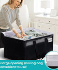 Woman using Extra Large Moving Bags With Zipper And Handles 93L Or 125L Storage Totes in black for home organization.