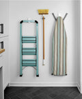 Wall showing Ten Pound Extra Large Heavyweight Wall Hooks With Adhesive Strips holding a ladder, broom, and ironing board.