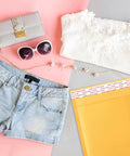 Yellow Kraft Bubble Mailers 25 Pack Self Sealing Padded Envelopes 10.5 By 16 Inch Outer Size next to sunglasses and clothes