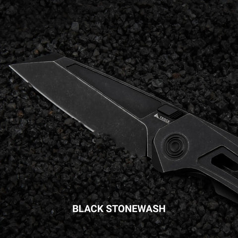 Black titanium pocket knife with M390 powder steel blade, thumb hole, and stonewash finish on rough black stones