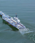 Dual-Motor 30 Km/H RC Battleship With Waterproof Hull And Sealed Cabin cruising smoothly on a lake, showcasing its high-speed design.
