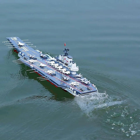 Dual-Motor 30 Km/H RC Battleship With Waterproof Hull And Sealed Cabin cruising smoothly on a lake, showcasing its high-speed design.