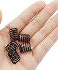 Hand holding stainless steel compression springs 1.2x13x15mm small mechanical springs for appliance repair DIY projects gear home shop use