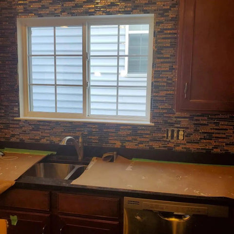 Interlocking Metallic Glass Tile Mosaic In Rose Gold Silver And Ink Blue For Kitchen Backsplash installed around a window.