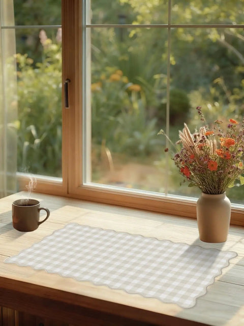 Scalloped Beige Checkered Gingham Desk Pad Large Mouse Pad For Keyboard And Computer, Cozy Cottagecore Vibe Vintage Rustic Aesthetic Office Mat, 31 By 15.7 Inches on a wooden desk by a window.