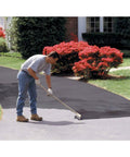 Man applying Black Driveway Sealer 5 Gallon With 7 Year Warranty Durable Asphalt Sealant For Long Lasting Protection And A Smooth Finish
