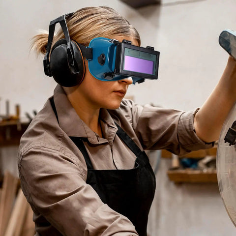 Boss Grade Auto Darkening Welding Goggles Heavy Duty Industrial Safety Glasses With Lightning Shade Switch For Grinding Soldering And Precision Steel Fabrication In Navy Blue worn by a woman using tools.