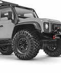 Rockin Metal Electric RC Winch For Mini 1/18 Trx4m And 1/24 Fms Crawlers mounted on a crawler truck front bumper with large tires.