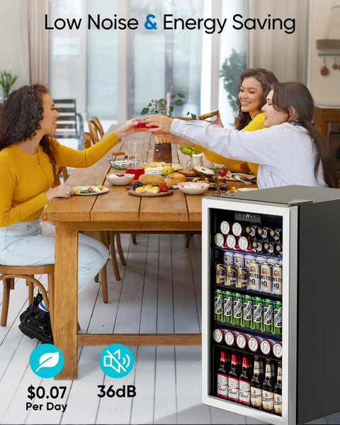 126 Can Beverage Refrigerator With Glass Door 3.2 Cu Ft Mini Fridge For Your Home Bar Office Or Bedroom 4 Adjustable Shelves Holds Soda Beer And Wine Quiet Energy Efficient Cooler next to a dining table with people enjoying a meal.