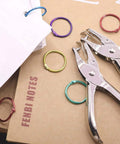 Dual Hole Punch Set With One Quarter Inch And One Eighth Inch Holes, Handy Single Hole Punch displayed with colorful rings for DIY crafts