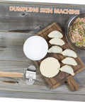 Knock Out Perfect Dumpling Wrappers Effortlessly With This Three Piece Stainless Steel Roller Set Designed For Quick Shaping And Easy Cleanup A Legit Game Changer For Home Chef Essentials Daily. Dumpling skin machine with stainless steel roller and wooden handle, dough and filling on a wooden board.