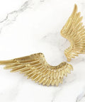 Heavy Duty Solid Brass Wardrobe Handles Featuring Slick Matte Gold Angel Wing Design and Badass Cabinet Knobs, close-up view.