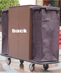 Back view of Straight Up Heavy Duty Three Tier Cleaning Cart With Two Roomy Cabinets And Smooth Rolling Wheels For Hotel Housekeeping Hustle.