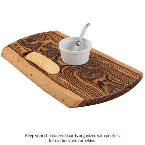 Wooden charcuterie board with crackers and ramekin, featuring natural wood grain and smooth finish, viewed from above.