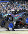 Large 1:8 Scale Monster Truck RC Car for adults and teens jumping over a ramp in a stadium, off-road 4WD all-terrain crawler.