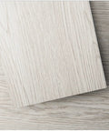 Close-up of Peel And Stick Vinyl Wood Floor Tiles 54 Sq Ft White Washed Plank 36 Pack Rigid Core Self Adhesive Flooring texture.