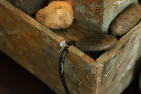 Close-up of Spillway Rustic Indoor Tabletop Water Fountain With Slate And Copper Finish, showing stones and copper detailing