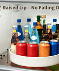 Large Capacity Lazy Susan Organizer For Pantry Cabinet And Kitchen Storage Featuring Super Slick 360 Spinner Turntable Spice Rack With Non Slip Base And Raised Lip Saves Serious Space While Making Daily Meal Prep A Total Piece Of Cake with 2-inch raised lip and assorted bottles in refrigerator.
