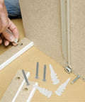 Person installing Heavy Duty Wall Anchors And Screws Kit, 50 Sets, Stainless Steel And Plastic Construction, showing anchors and screws