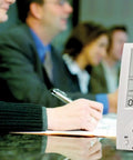 Desktop Indoor CO2 And Air Quality Monitor For Home Or Office With NDIR Sensor on conference table, tracking CO2 levels.