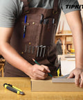 Woodworking Apron With 9 Tool Pockets And Magnetic Chest Holders, 20 Oz Waxed Canvas Apron in use by a carpenter drawing.
