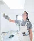 Person painting a room wearing Rival Safety Glasses For Work And Lab With Clear Lenses And Scratch-Resistant Hard Coat