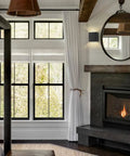 Black cordless LED cube wall sconces with remote dimmable up and down lighting near fireplace in modern living room.