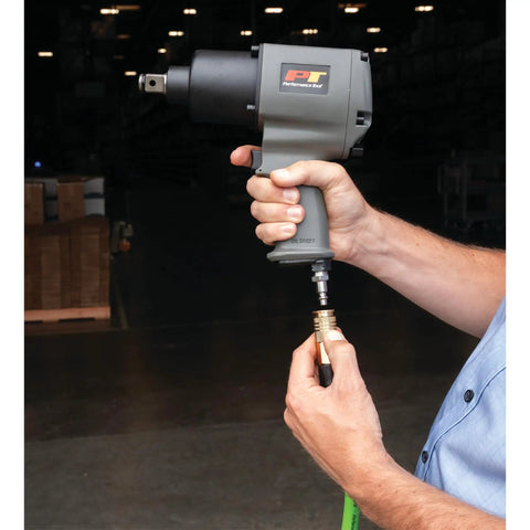 M627 3 Quarter Inch Drive Heavy Duty Impact Wrench With Aluminum Housing in hand at an auto shop entrance