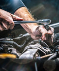 Mechanic using tool near car engine, illustrating Heavy Duty Cleaning Wipes 260 Count Bulk Pack With Dual Texture For Hands And Surfaces.