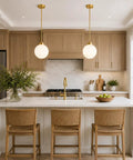 Two Pack Brushed Gold Globe Pendant Lights With Mid Century Modern Vibes And Smooth Opal Glass Shades Totally Adjustable Hanging Fixtures above kitchen island.