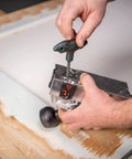 Person attaching Replacement Carbide Blades for Model 00714 Paint Remover, 10 Pack, on a wooden surface