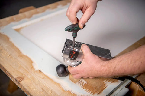 Person attaching Replacement Carbide Blades for Model 00714 Paint Remover, 10 Pack, on a wooden surface