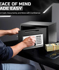 Person using drop slot money safe box with digital keypad lock for home office or cabinet, securing cash and documents.
