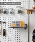 Hollow Wall Anchors And Stainless Steel Screws Kit For Drywall Mounting on a pegboard with storage jars, tools, and shelves.
