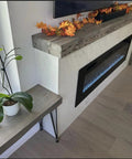 Kickass Water Based Wood Stain With A Slick Gray Brown Tint on a smooth wooden mantel above a modern electric fireplace.
