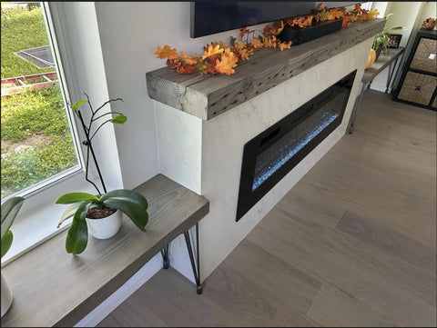 Kickass Water Based Wood Stain With A Slick Gray Brown Tint on a smooth wooden mantel above a modern electric fireplace.