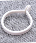 Single white ring from 60 Pack Plastic Circular Curtain Rings For Rods With Smooth Glide No Burr displayed on a textured surface