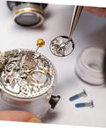 Close-up of 100Pcs Eyeglass Repair Screws Kit For Quick Eyewear Fixes with tools and intricate watch mechanism in view
