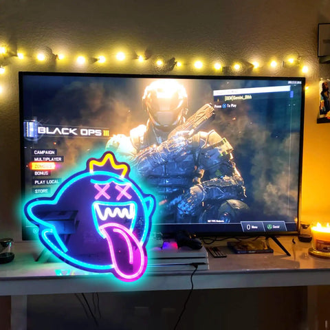 Totally Lit Ghost Neon Sign LED Light with dimmable switch and colorful rainbow glow next to gaming setup, USB powered, easy mount.