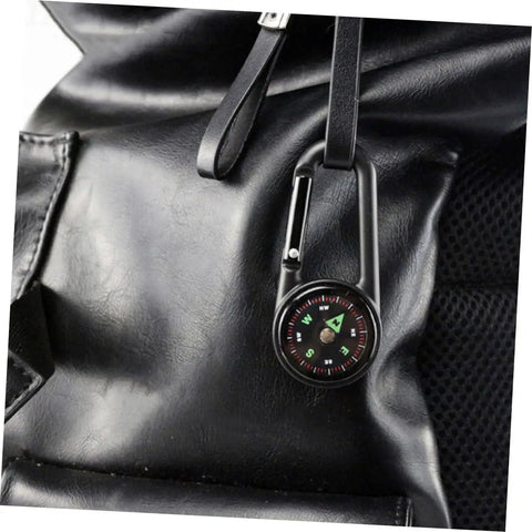 Portable Double Sided Hiking Compass With Carabiner Pocket Sized Mini Outdoor Navigation Tool clipped to a backpack