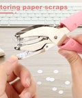 1/4 Inch Circle Hole Punch Handheld Paper Punch with pink grip for crafts and scrapbooking shown punching paper on a desk