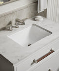 Roomy Rectangular Undermount Bathroom Sink With Overflow Drain Crafted From Hella Durable Vitreous China For An Easy Vanity Setup Bringing Straight Up White Finish And Really Smooth Daily Performance on a marble countertop.